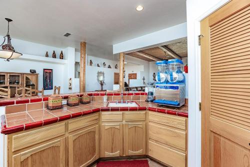 a kitchen with wooden cabinets and a red counter top at Havasu River Stay Pool Spa OutdoorTV Views in Lake Havasu City
