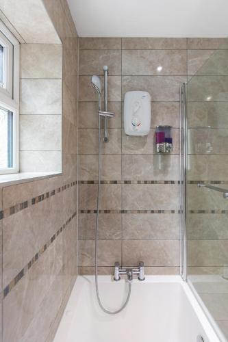 a bathroom with a shower with a bath tub at Chicstay Suites in High Wycombe