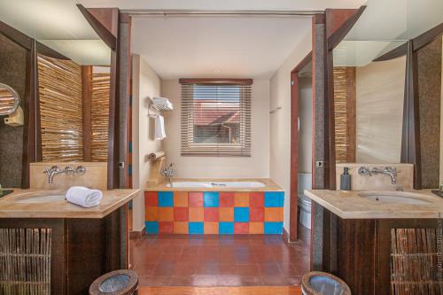 a bathroom with two sinks and a tub at Villa Les Agaves front de mer in Le François