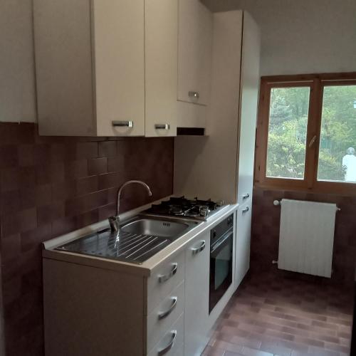 a kitchen with a sink and a stove at Casa Vacanza Kairos in Ponzone