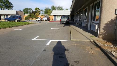 a shadow of a person standing in a parking lot at Pacific Motel in Gridley