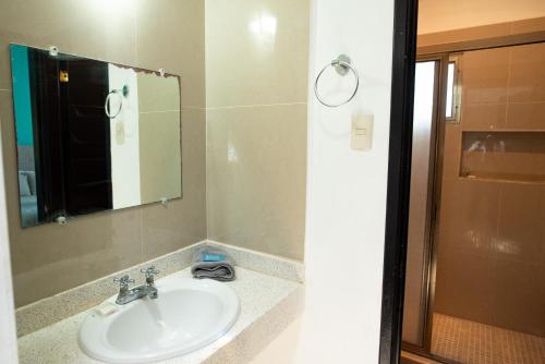 a bathroom with a sink and a mirror at Modern villa with private pool, 1 block from the Ocean in Chicxulub