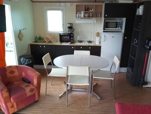 a kitchen with a table and chairs in a room at Mobil-home a la campagne proche de la mer in Criel-sur-Mer