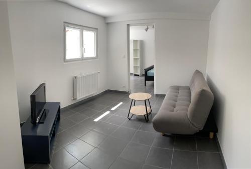 un salon avec un canapé et une table dans l'établissement Un T2 tout confort spacieux - Résidence SJT, à Aleçon