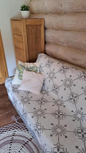 a bed in a bedroom with a wooden wall at Brīvdienu lauku māja in Garkalne