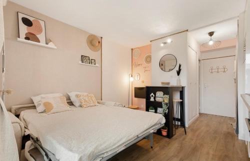 une petite chambre avec un lit et un miroir dans l'établissement La perle du port, au Cap d'Agde