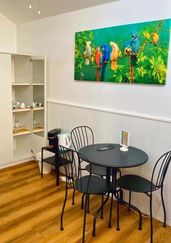 a table and chairs in a room with a painting on the wall at Naval Guest House in Vila do Conde