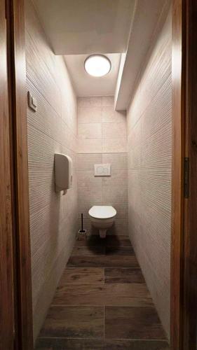 a small bathroom with a toilet and a light at Planinski dom - Mihov dom na Vršiču in Kranjska Gora