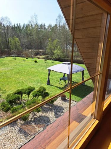a view from a window of a picnic table on a lawn at Brīvdienu lauku māja in Garkalne