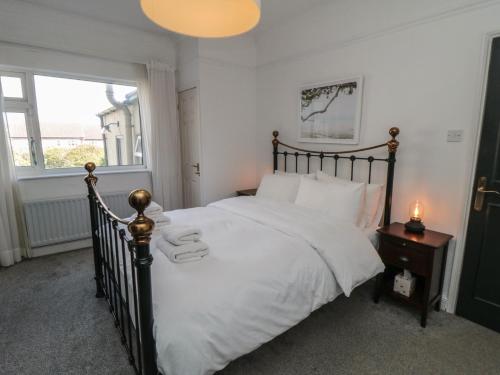 a bedroom with a bed with white sheets and a window at Top-Notch Flat in Saltburn-by-the-Sea