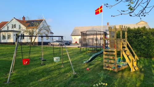 a playground with a slide and a swing set at Kvarnviks Gård Close to Sea & Charming Country Stay in Klagstorp