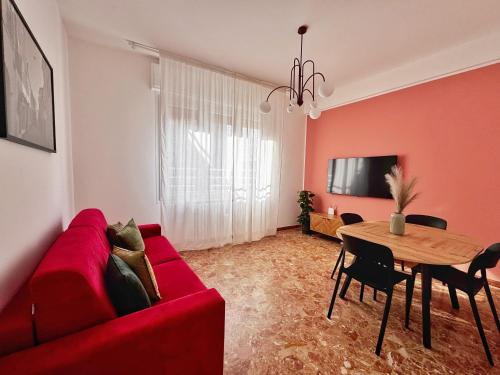 a living room with a red couch and a table at Dimora Pasolini in Ravenna