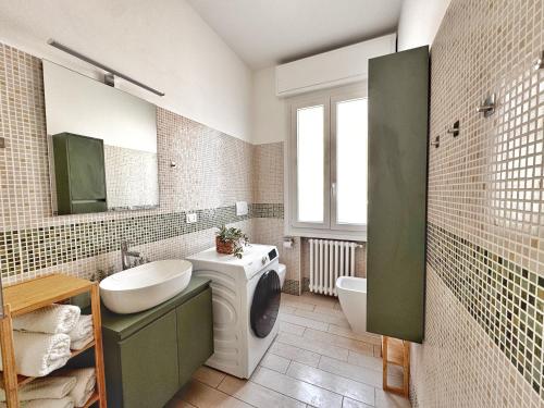a bathroom with a sink and a washing machine at Dimora Pasolini in Ravenna