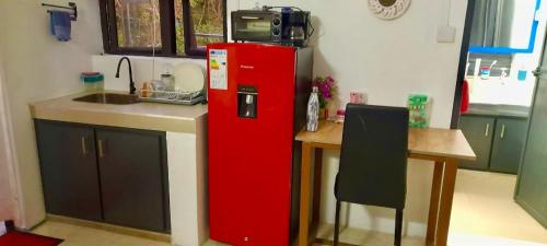 a kitchen with a red refrigerator next to a table at Villasjohnclair in Eau Vanée