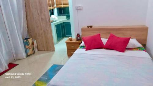a bedroom with a bed with two red pillows at Villasjohnclair in Eau Vanée