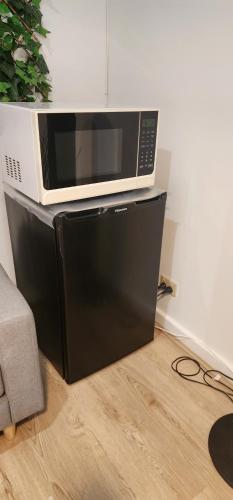 a microwave sitting on top of a black refrigerator at The Hancock Homestead in Teatree Gully