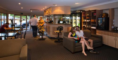 
people sitting on couches in a living room at James Street Motor Inn in Toowoomba
