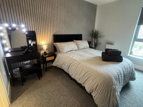 een slaapkamer met een bed, een tafel en een spiegel bij 2 Bedroom Apartment - Henry St Central Liverpool in Liverpool
