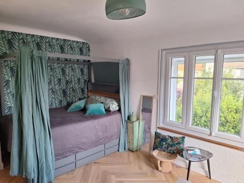 une chambre avec un lit dans une pièce avec des fenêtres dans l'établissement Villa Bleue au Roucas Blanc - Piscine & Mer - du samedi au samedi, à Marseille