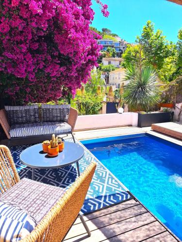 un patio avec une table et des chaises à côté d'une piscine dans l'établissement Villa Bleue au Roucas Blanc - Piscine & Mer - du samedi au samedi, à Marseille