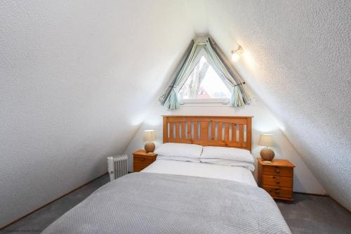 een kleine slaapkamer met een bed en een raam bij Chalet Fortyfive in Deal
