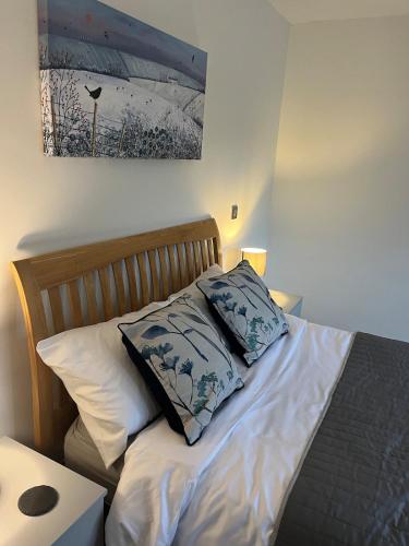 a bed with two pillows on top of it at The Suite in Bourton on the Water
