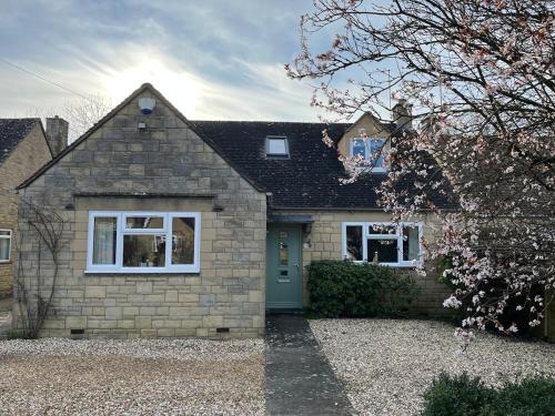 a brick house with a blue door at The Suite in Bourton on the Water