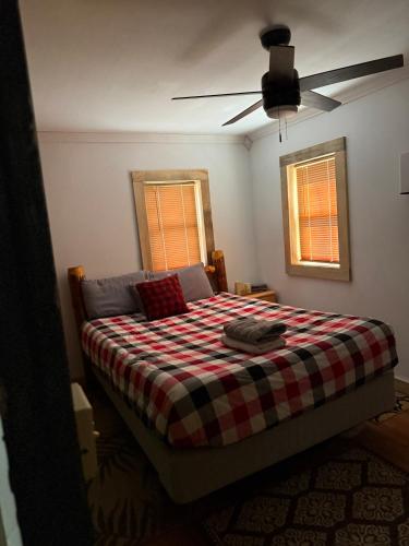 a bedroom with a bed with a checkered blanket at The Cabins at Walnut Grove-minutes from Hunter and Windham in Ashland