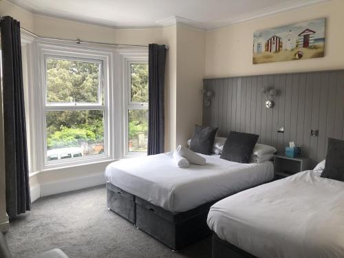 a hotel room with two beds and a window at Spindrift Guest house in Great Yarmouth