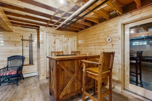 a log cabin kitchen with a wooden counter and chairs at Mooseleuk Lodge in The Highlands