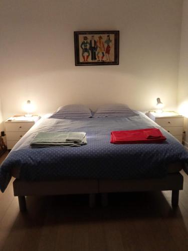 une chambre avec un lit avec deux serviettes dessus dans l'établissement Au jardin croix roussien, à La Celle-sous-Gouzon