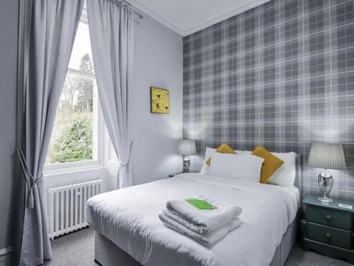 a bedroom with a bed with towels on it at McInnes House rooms with breakfast in Kingussie
