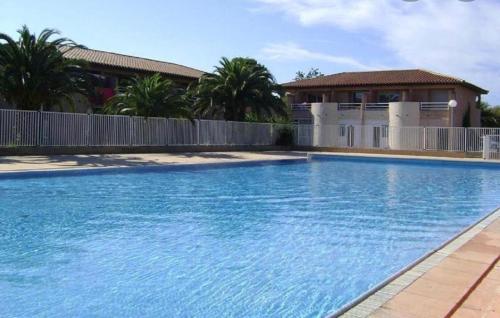 une grande piscine bleue devant une maison dans l'établissement Pour 4 personnes, 15 minutes à pied de la plage, à Saint-Cyprien