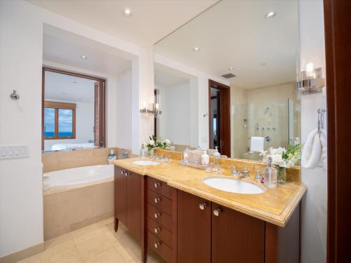 a bathroom with a sink and a bath tub and a mirror at Freshly Renovated, Spectacular Ocean Views, Ultra-Luxe Blue Ocean Suite H401 in Wailea