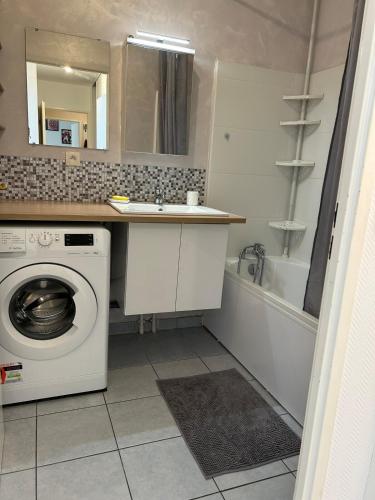 une salle de bain avec une machine à laver et un lavabo dans l'établissement Charmant 2P Cosy Bord de Seine avec terrasse, à Mantes-la-Jolie