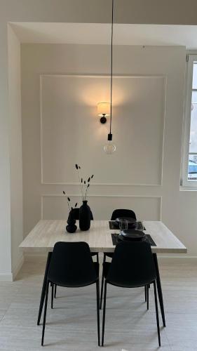 a dining room table with black chairs and a light fixture at Il Giardino - Holiday lake home in Iseo