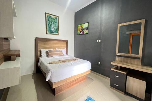 a bedroom with a bed and a television in it at Belvilla Moksha Haven Pandawa BaliNearNirwana Garden Bali in Jembrana