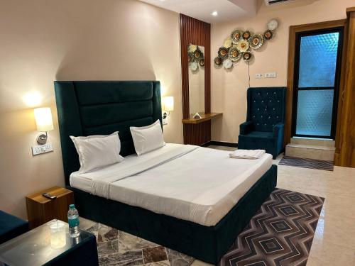 a bedroom with a large bed and a blue chair at Hotels7Apple in Mahoba