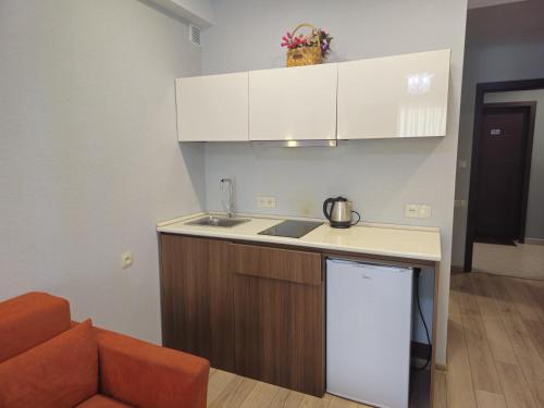 a kitchen with white cabinets and a counter top at Bakuriani Crystal in Bakuriani