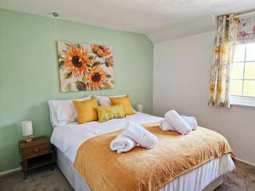 a bedroom with a bed with two towels on it at Lily Cottage in Marldon