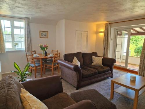 a living room with a couch and a table at Lily Cottage in Marldon