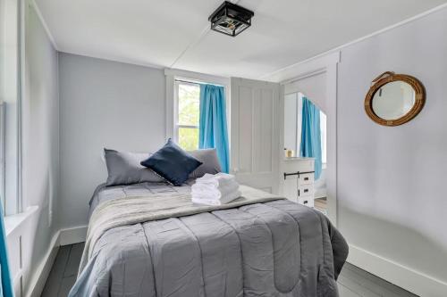 a bedroom with a bed with blue curtains and a mirror at Spacious Lakeside Retreat 4-Bedroom Game Room in Orono