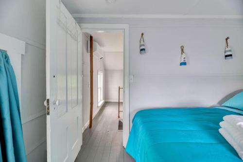 a bedroom with a blue bed and a white wall at Spacious Lakeside Retreat 4-Bedroom Game Room in Orono