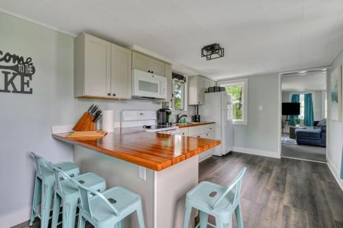 a kitchen with white cabinets and blue stools at Spacious Lakeside Retreat 4-Bedroom Game Room in Orono