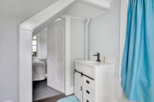 a white bathroom with a sink and a mirror at Spacious Lakeside Retreat 4-Bedroom Game Room in Orono