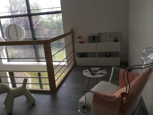 Habitación con balcón con silla y mesa. en Le confort contemporain dans un écrin de verdure, en Vernon