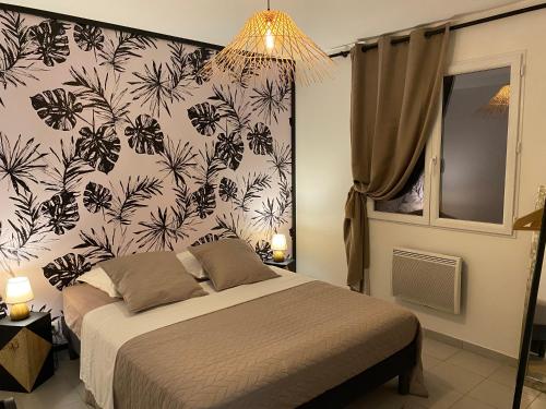 a bedroom with a bed with a black and white wallpaper at Gîte avec spa in Saint-Avit-Sénieur
