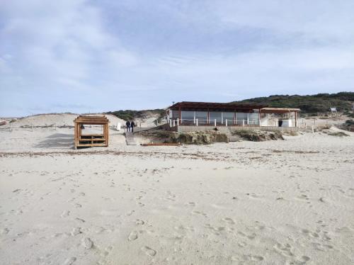 ein Gebäude am Strand mit Fußabdrücken im Sand in der Unterkunft Rena Majore Home in Rena Majore