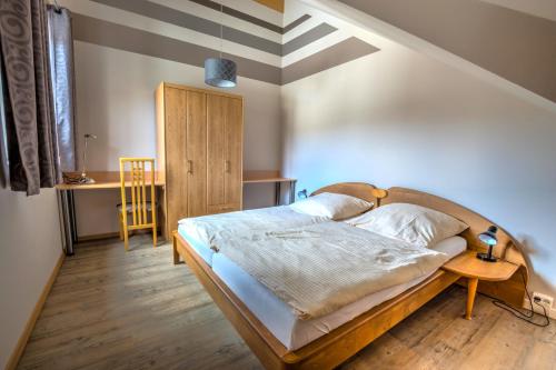 a bedroom with a bed and a table with a chair at Naturlaub-Domizil Oster-Franzen in Bremm