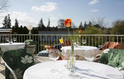 a table with wine glasses and a flower on a patio at Hotel Atrium in Vyškov